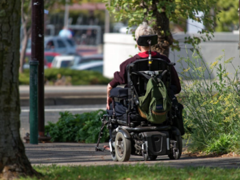 A person with Motor Neurone Disease using a Wheelchair Mobility Aid.