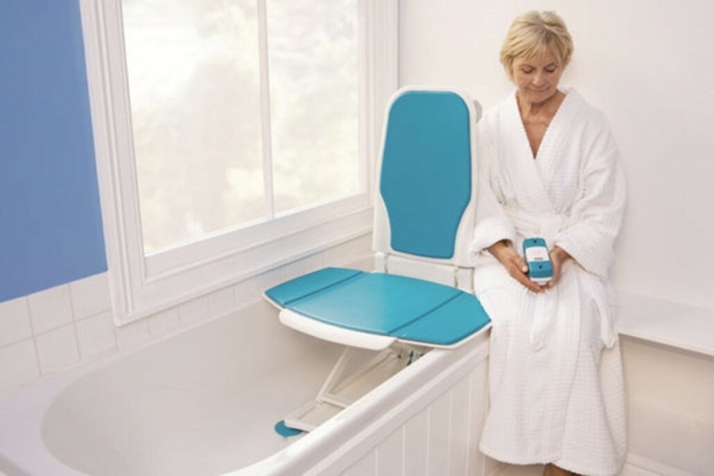 Woman looking at a remote, wondering what a bath lift is and how she can use it.